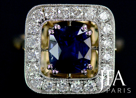 Belle bague en or jaune et platine sertie d´un saphir et d´un entourage de diamants .

Nous attirons votre attention sur la qualité des découpes du panier de cette bague. Une alliance s'y juxtaposera parfaitement.

Une pierre de forme coussin carrée, montée sur un corps de bague en or jaune, demi jonc rond et conforable.

La fabrication de cette bague a nécessité l´intervention de nos quatre artisans experts spécialisés : le dessinateur, le joaillier, le sertisseur et la polisseuse.