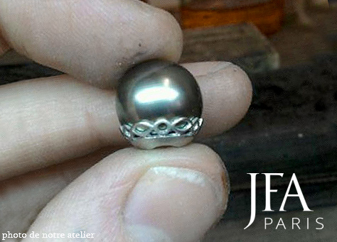 Belle bague en platine sertie d´une perle de Tahiti de 13 mm et de deux diamants coeur pour 1ct.

Cette bague est entièrement réalisée à la main, comme nous le faisons d´habitude, cela se remarque particulièrement sur le reperçé du panier soutenant la perle.

La fabrication de cette bague a nécessité l´intervention de quatre artisans spécialisés. Le dessinateur, le joaillier, le sertisseur et la polisseuse.