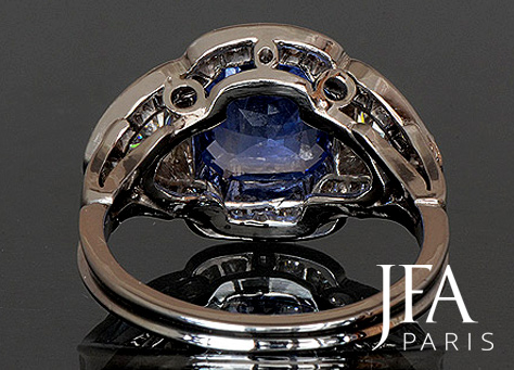 Bague en or gris sertie en son centre d´un saphir de Ceylan de 2,70 ct environ, de deux diamants troïda de 0,30 ct chacun et d´un entourage de diamants brillantés.

Pierre provenant de notre collection.

La fabrication de cette bague a nécessité l´intervention de quatre artisans spécialisés : le dessinateur, le joaillier, le sertisseur et la polisseuse.