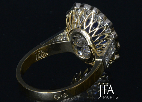 Très élégante bague en or et  platine sertie d´un saphir ovale et d´un double entourage de diamants alternés de saphirs.

La monture de cette bague, d´un modèle classique, a été réalisé entièrement à la main.

Nous attirons votre attention sur le panier de cette bague qui est forgé directement dans le métal comme cela se fait rarement de nos jours.

La fabrication de cette bague a nécessité l´intervention de quatre artisans spécialisés : le dessinateur, le joaillier, le sertisseur et la polisseuse.